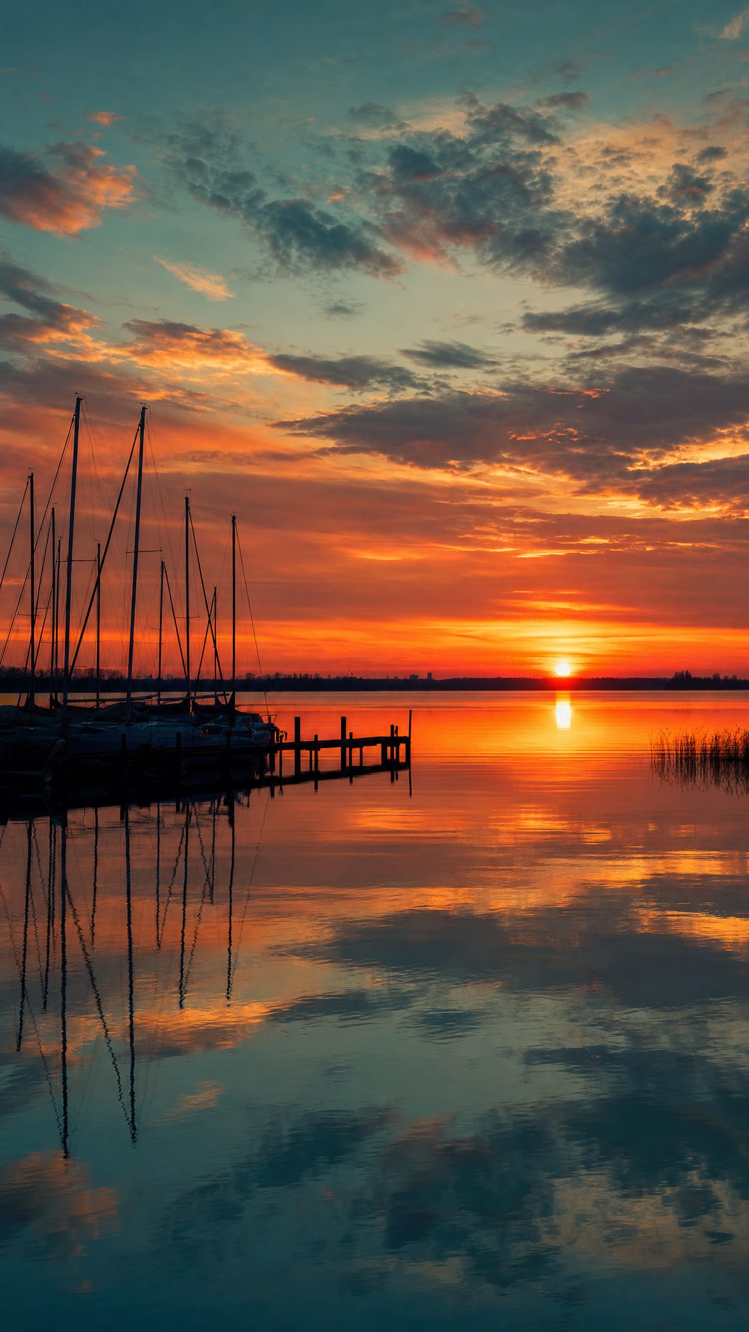 Naplemente a Balaton fölött, vitorlásárbocok sziluettje a kikötőben
